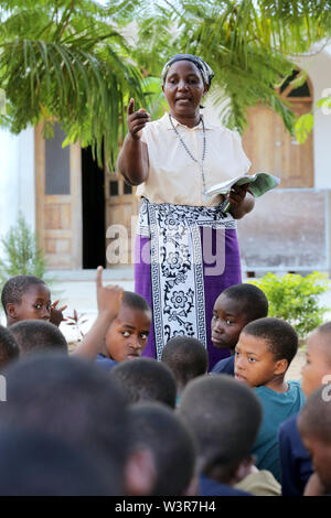 Catechist teaches catholic religion classes with students from Epiphany Pre- and Primary School in Bagamoyo, Tanzania Stock Photo