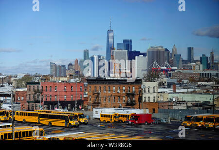school buses parked in Red Hook Brooklyn with downtown Manhattan in the background Stock Photo