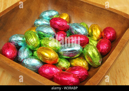 Chocolate colorful eggs mettalic foiled in wooden bowl Stock Photo