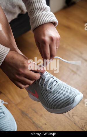 Getting ready for morning jog- woman tying shoe laces- detail Stock Photo