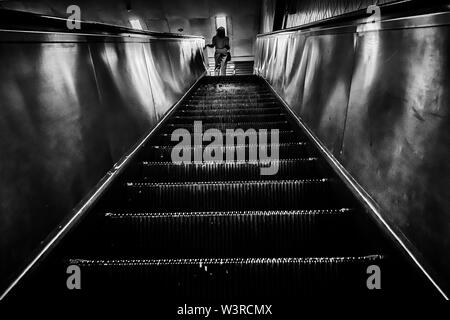 Singapore - Oct 19, 2018: A woman going up the escalator and reach the ground floor at Toa Payoh MRT Station, Singapore. Stock Photo