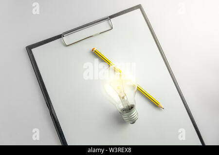 Blank paper with an light bulb and pencil waiting for idea concept with light Stock Photo