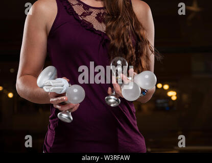 Woman holding various light bulbs Stock Photo