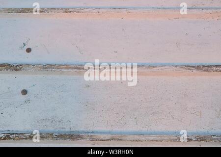 Closeup of the bottom of a white painted fishing boat with three horizontal lines in the soft evening light Stock Photo
