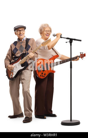 Full length portrait of a senior couple with electric guitars singing on a microphone isolated on white background Stock Photo