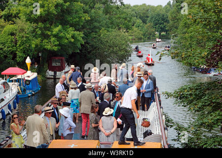 Hurley, Berkshire, UK. 17th July, 2019. Passengers on board the Waterman following the swan uppers as they leave Hurley Lock on day three of Swan Upping 2019. A week long survey of the the swans on the River Thames, from Sunbury in Surrey to Abingdon in Oxfordshire. The Royal Swan Uppers, who wear the scarlet uniform of Her Majesty The Queen, travel in traditional rowing skiffs together with Swan Uppers from the Vintners' and Dyers' livery companies. Credit: Julia Gavin/Alamy Live News Stock Photo