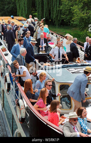 Hurley, Berkshire, UK. 17th July, 2019. Passengers on board the Waterman following the swan uppers as they leave Hurley Lock on day three of Swan Upping 2019. A week long survey of the the swans on the River Thames, from Sunbury in Surrey to Abingdon in Oxfordshire. The Royal Swan Uppers, who wear the scarlet uniform of Her Majesty The Queen, travel in traditional rowing skiffs together with Swan Uppers from the Vintners' and Dyers' livery companies. Credit: Julia Gavin/Alamy Live News Stock Photo