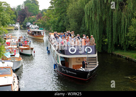 Hurley, Berkshire, UK. 17th July, 2019. A flotilla of boats including the Waterman follow the swan uppers as they leave Hurley Lock on day three of Swan Upping 2019. A week long survey of the the swans on the River Thames, from Sunbury in Surrey to Abingdon in Oxfordshire. The Royal Swan Uppers, who wear the scarlet uniform of Her Majesty The Queen, travel in traditional rowing skiffs together with Swan Uppers from the Vintners' and Dyers' livery companies. Credit: Julia Gavin/Alamy Live News Stock Photo