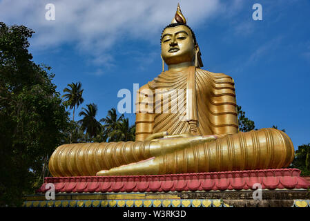 The colourful temple of Wewurukannala Vihara, 2 miles north of Dikwella, home to the largest seated golden Buddha in Sri Lanka, Asia. Stock Photo