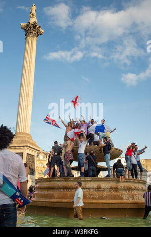 LONDON, UK -  JULY 14, 2019 :  Ecstatic fans celebrate in the fountains at Trafalgar Square after England's victory in the ICC Cricket World Cup Stock Photo