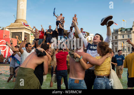 LONDON, UK -  JULY 14, 2019 :  Ecstatic fans celebrate in the fountains at Trafalgar Square after England's victory in the ICC Cricket World Cup Stock Photo