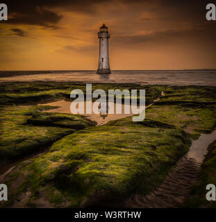 this image was taken at the golden hour at new Brighton lighthouse on the wirral, I just loved the reflection in the Rockpool showing the top Stock Photo
