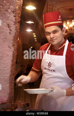 Man slicing meat at The Konak Restaurant on Istiklal Caddesi in Istanbul Turkey Stock Photo