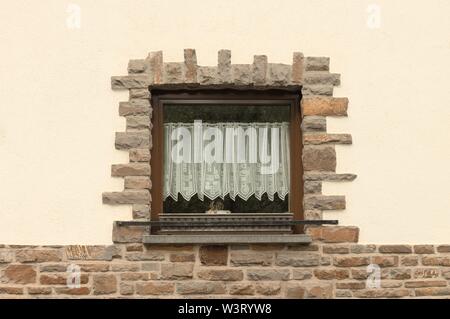 Isolated window framed by bricks with a white curtain (Germany, Europe) Stock Photo