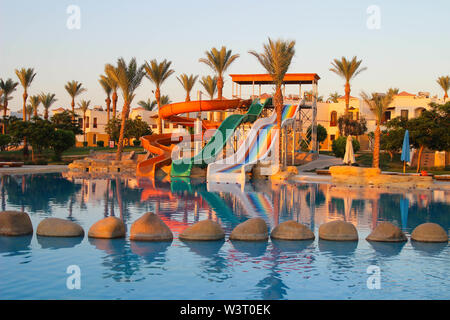 Water colorful rainbow slides with swimming pool in the hotel at dawn in Egypt. Water sport intertainment Stock Photo