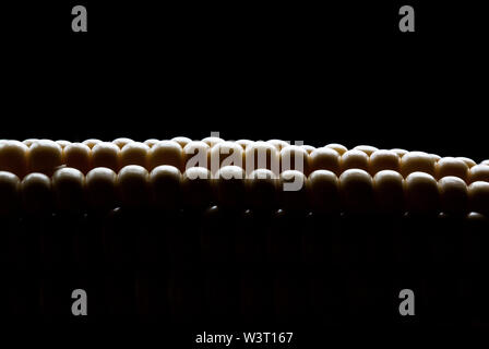 Extreme close up shot of corn cob against dark background. Stock Photo