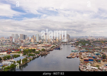 The urban landscape of Manila, with slums and skyscrapers. Sea port and residential areas. The contrast of poor and rich areas. The capital of the Philippines, view from above. Stock Photo