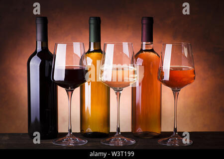 types of wine in bottles and glasses, red, white and rosé wine on rustic wooden table Stock Photo