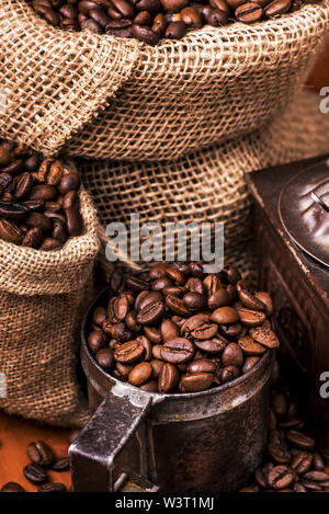 an old rustic wooden table top with coffee beans in jute sack Stock Photo