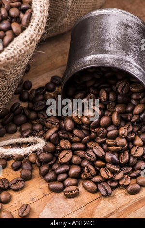 an old rustic wooden table top with coffee beans in jute sack Stock Photo