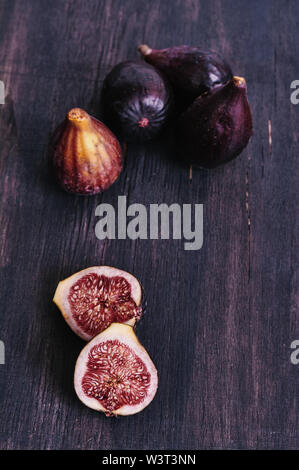 Figs isolated on dark wood background Stock Photo