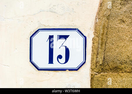 house number thirteen ( 13 ) on a roughcast wall Stock Photo