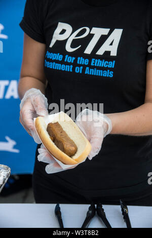 Washington DC, July 17, 2019, USA:A PETA volunteer holds a meatless dog at the annual PETA (People for the Ethical Treatment of Animals) Veggie dog lunch in front of the Rayburn House office building in Washington DC. PETA provided meat free hot dogs to crowds outside the building. Patsy Lynch/MediaPunch Stock Photo