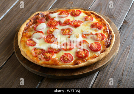 Pizza Margarita on wooden cutting board, close up Stock Photo