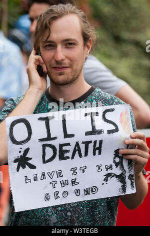 London, UK. 17 July, 2019. A climate activist from Extinction Rebellion with a ‘Oil is Death’ sign on Hammersmith bridge during a Critical Mass bicycle ride from Waterloo Millennium Green to Hammersmith Town Hall on the third day of their ‘Summer uprising’. The activists have three demands for Hammersmith and Fulham Council: to pass the proposed motion to declare a Climate Emergency; to keep Hammersmith bridge closed to vehicles; and to commit to safer cycling routes. Credit: Mark Kerrison/Alamy Live News Stock Photo