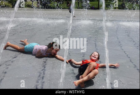 Washington, USA. 17th July, 2019. Kids play at a fountain at Georgetown Waterfront Park in Washington, DC, the United States, on July 17, 2019. The highest temperature reached 36 degrees Celsius in Washington, DC on Wednesday as a result of a prolonged heat wave. Credit: Liu Jie/Xinhua/Alamy Live News Stock Photo