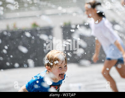 Washington, USA. 17th July, 2019. Kids play at a fountain at Georgetown Waterfront Park in Washington, DC, the United States, on July 17, 2019. The highest temperature reached 36 degrees Celsius in Washington, DC on Wednesday as a result of a prolonged heat wave. Credit: Liu Jie/Xinhua/Alamy Live News Stock Photo