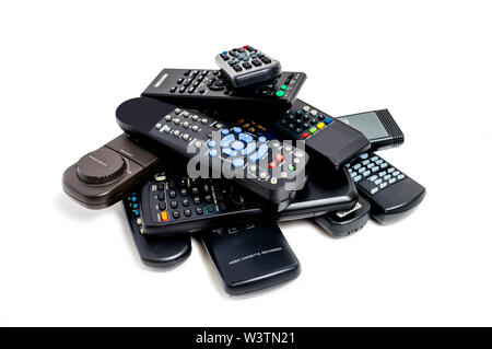 Horizontal shot of a lot of old remote controls piled high. White background. Stock Photo