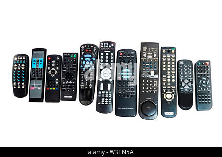 Horizontal shot of a row of eleven lined up remote controls.  Different sizes and button configurations.  White background. Stock Photo