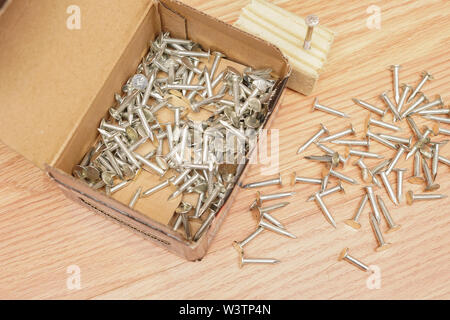 Small nails in a box and on the floor getting ready to be used for a home construction project.  Photo Credit:  Marty Jean-Louis Stock Photo