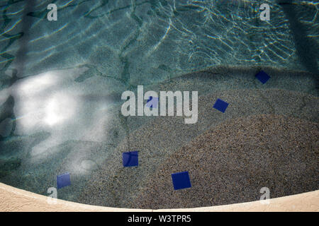 steps down into a backyard pool as the sun shines on the surface USA United States of America Stock Photo