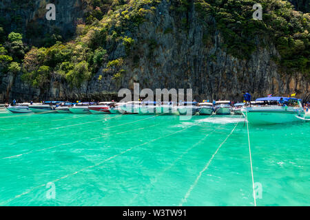 Phi Phi Lay island, Thailand, March 2013 Speed or motor boats docking on anchors with long ropes near cliff in Maya Bay, one of the iconic beaches of Stock Photo