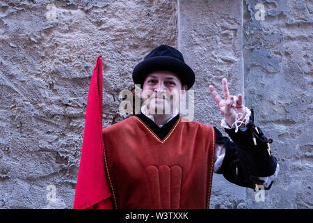 A man in medieval costume gives peace sign before the beginning of the Palio parade and event in Siena, Italy Stock Photo