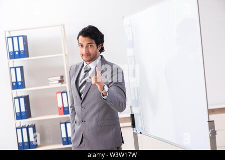 Theyoung handsome businessman in front of whiteboard Stock Photo