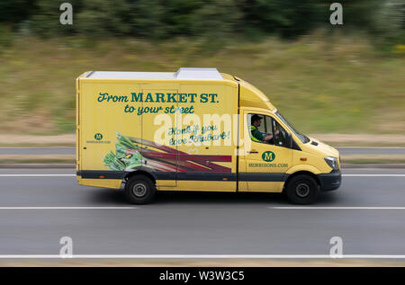 A Morrison's delivery van travels along the A556 road in Alderley Edge, Cheshire, UK. Stock Photo