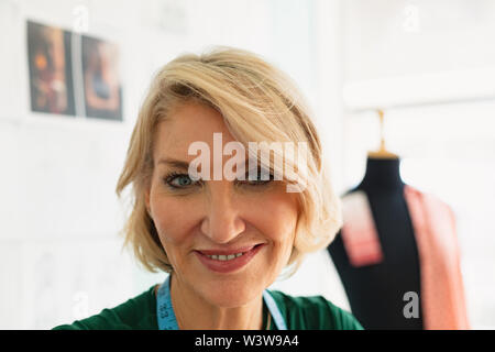 Happy female fashion designer smiling in the design studio Stock Photo