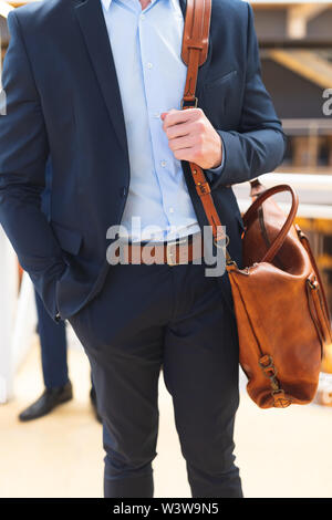 Businessman standing with office bag in the corridor at office Stock Photo