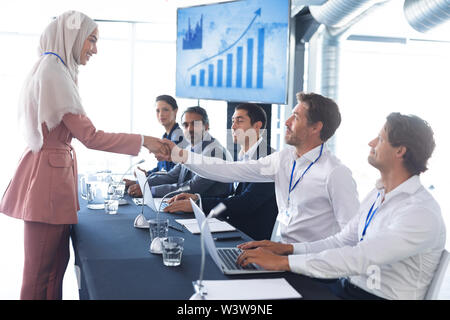 Business people shaking hands with each other while checking in business seminar Stock Photo