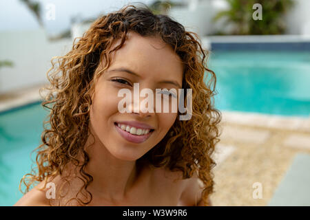 Happy woman relaxing near swimming pool in the backyard at home Stock Photo