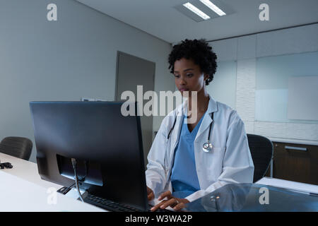 Female doctor working on computer at desk in hospital Stock Photo