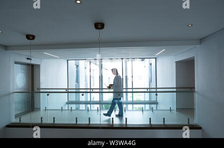 Male doctor using laptop while walking in the corridor Stock Photo
