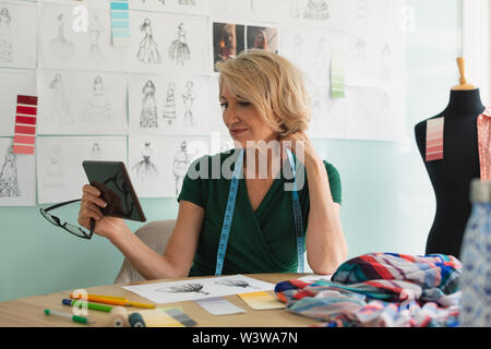 Female fashion designer taking selfie on digital tablet at desk Stock Photo