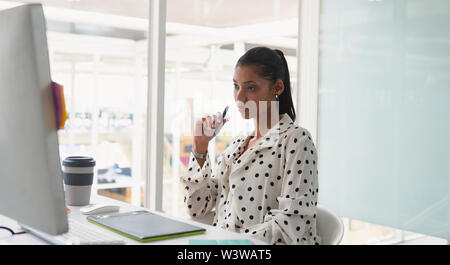 Female graphic designer using graphic tablet at desk Stock Photo