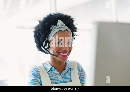 Happy female customer service executive talking on headset in office Stock Photo
