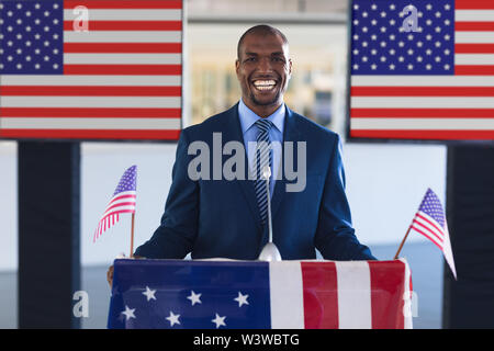 Male speaker smiling at podium table in a business seminar Stock Photo
