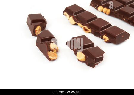 bar of dark chocolate with hazelnuts. Pieces of chocolate with nuts, isolated on white background. Stock Photo